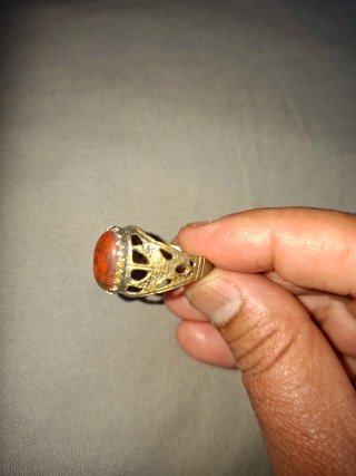 Anillo con piedra naranja y detalles plateados