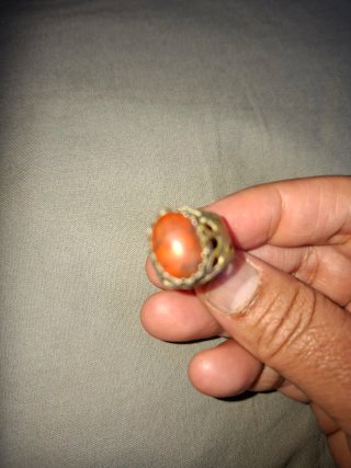 Anillo con piedra naranja y detalles plateados