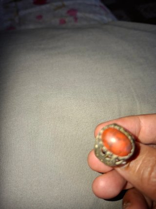 Anillo con piedra naranja y detalles plateados