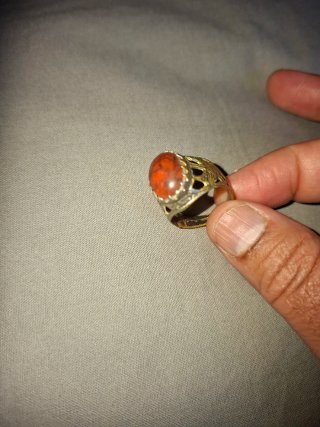 Anillo con piedra naranja y detalles plateados