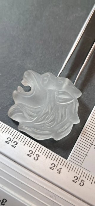 Ciondolo testa di leone in materiale sintetico.