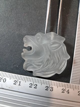 Ciondolo testa di leone in materiale sintetico.