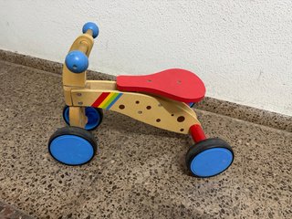 Triciclo de madera para niños en buen estado.