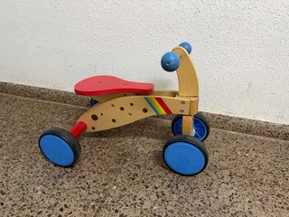Triciclo de madera para niños en buen estado.