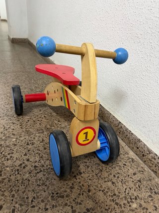 Triciclo de madera para niños en buen estado.