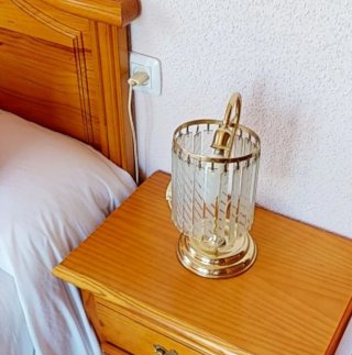Lámpara de mesa dorada y transparente