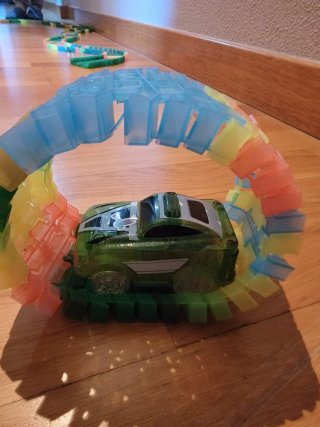 Pista de coches luminosos con dinosaurios