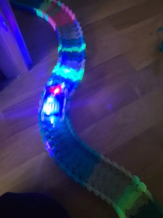 Pista de coches luminosos con dinosaurios