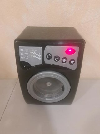 Lavadora de juguete con luces y sonido.
