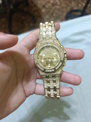 Reloj dorado con incrustaciones de diamantes falso