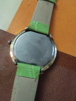 Reloj verde con detalles plateados