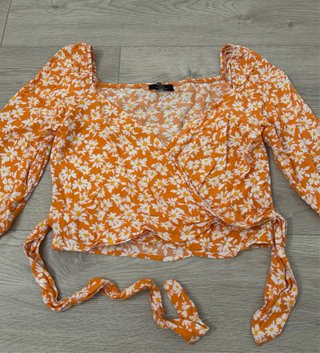 Blusa cruzada naranja con flores blancas