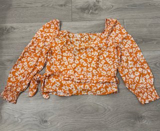 Blusa cruzada naranja con flores blancas