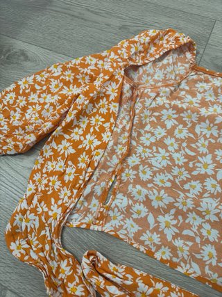 Blusa cruzada naranja con flores blancas