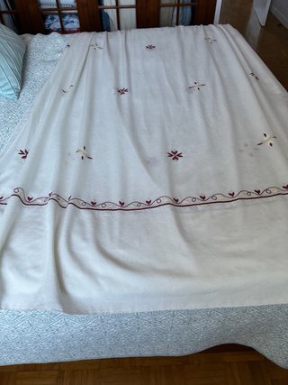 Juego de cortinas cremas con bordados granates.