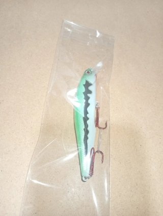 Señuelo de pesca verde con detalles negros