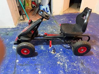 Coche a pedales negro con detalles rojos