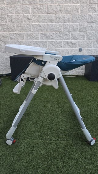 Trona reclinable con ruedas azul petroleo.