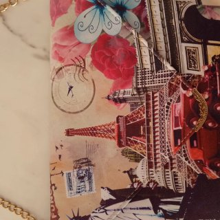Cartera de mano con cadena y diseño de viajes