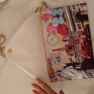 Cartera de mano con cadena y diseño de viajes