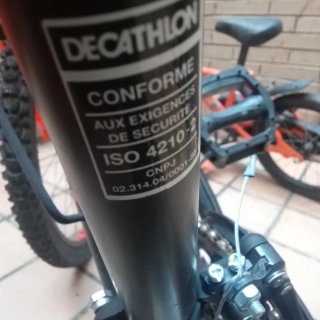 Bicicleta Rockrider con marchas, negra y naranja.