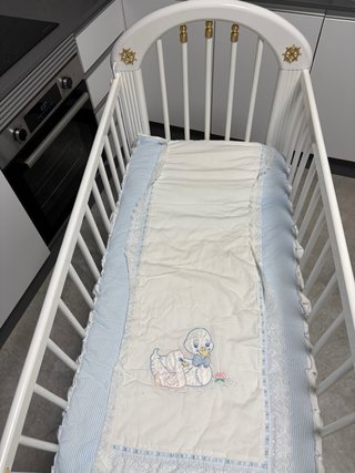 Cuna blanca con detalles dorados