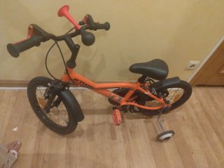 Bicicleta infantil naranja con ruedines