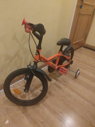 Bicicleta infantil naranja con ruedines
