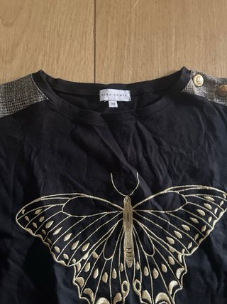 Camiseta negra con mariposa dorada
