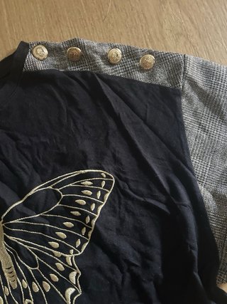 Camiseta negra con mariposa dorada