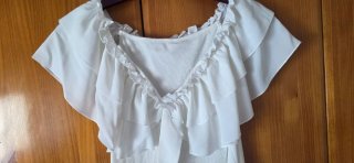Blusa blanca con volantes y lazada
