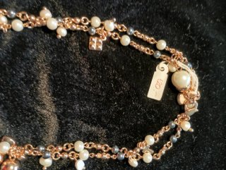 Collar de perlas blancas y negras con detalles dor