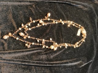 Collar de perlas blancas y negras con detalles dor