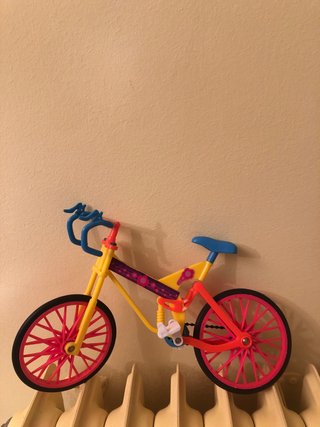 Bicicleta de juguete amarilla y rosa