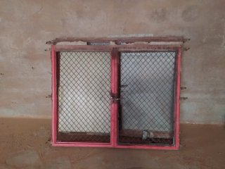 Ventana con reja metálica roja