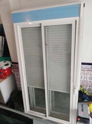 Ventana corredera blanca con persiana