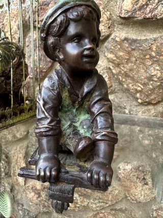 Niño de bronce con patinete