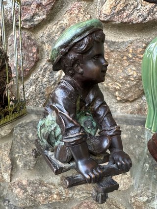 Niño de bronce con patinete