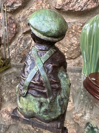 Niño de bronce con patinete