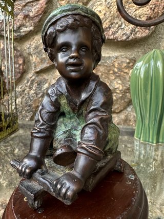 Niño de bronce con patinete