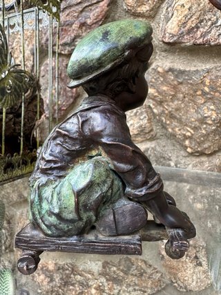 Niño de bronce con patinete