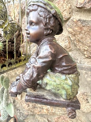 Niño de bronce con patinete