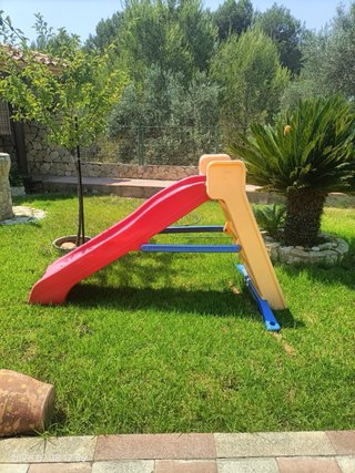 Casa de plástico para niños con tobogan y moto