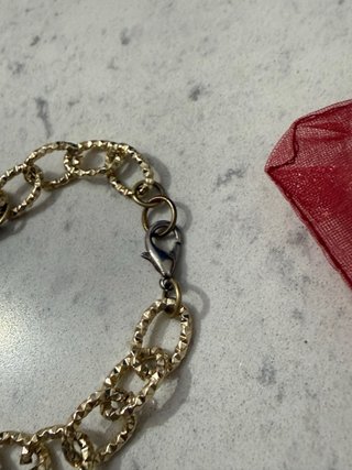 Pulsera dorada con charms y perlas
