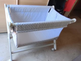 Cuna de bebé con juego de sábanas.