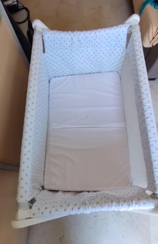 Cuna de bebé con juego de sábanas.