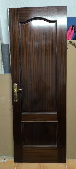 Puerta de madera oscura con manilla dorada