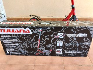 Patinete rojo plegable con su caja original.