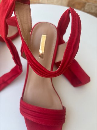 Sandalias rojas atadas al tobillo con lazo