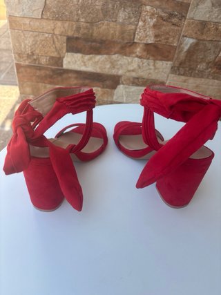 Sandalias rojas atadas al tobillo con lazo